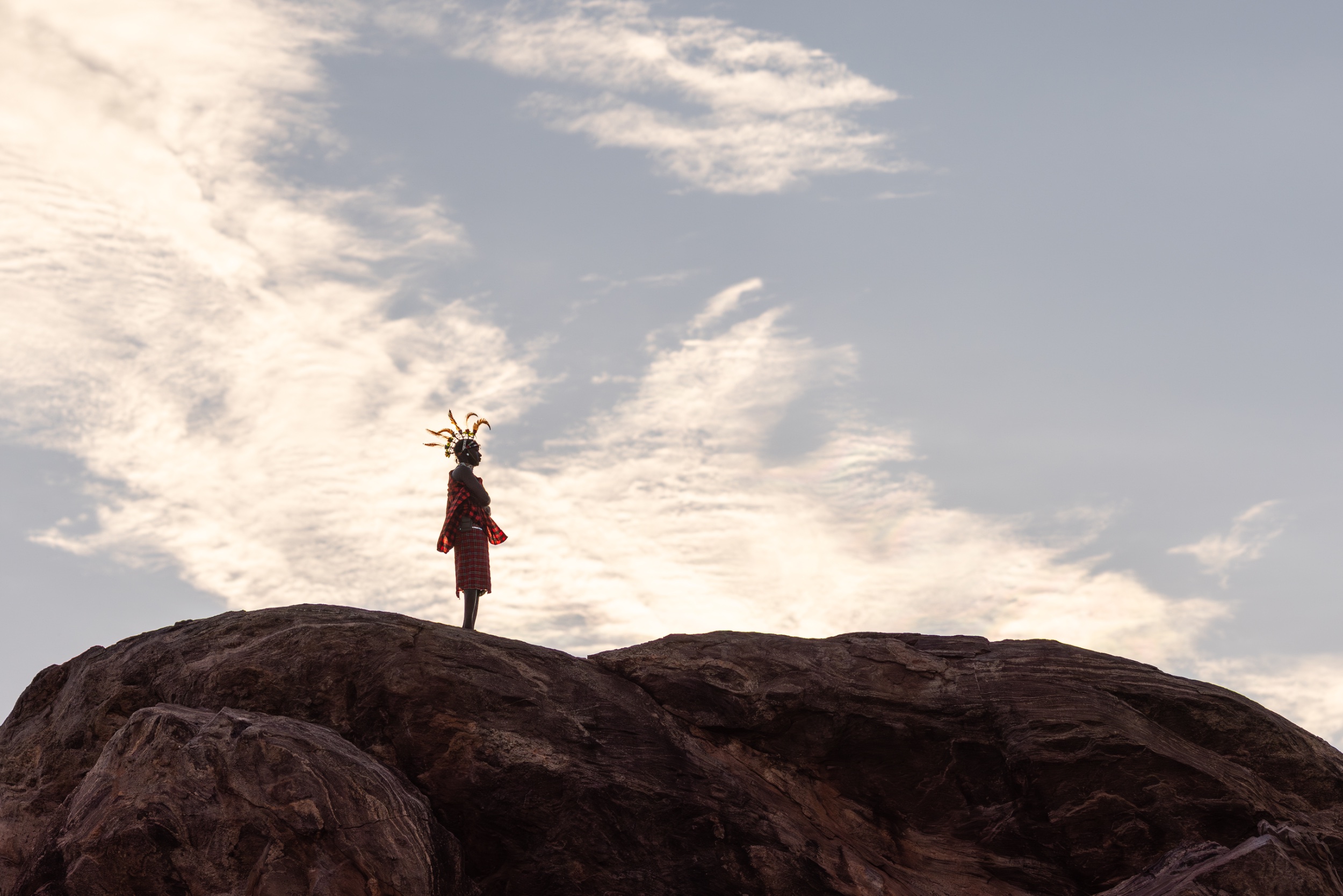 A figure standing on a granite kopje against an open sky, Loisaba, Kenya